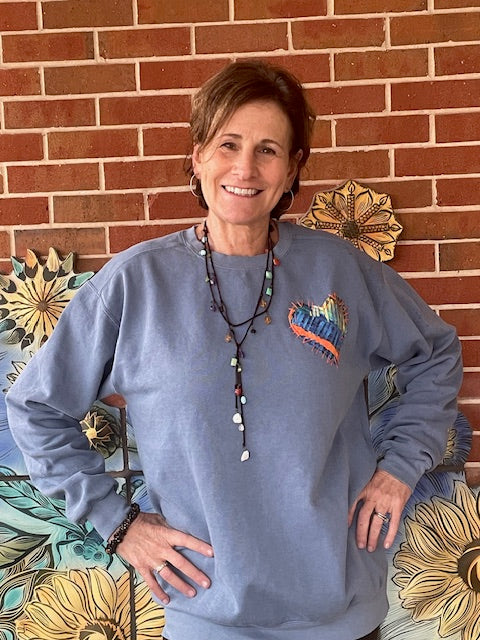 Female wearing a sweatshirt w/ Heart patch made of original artwork.