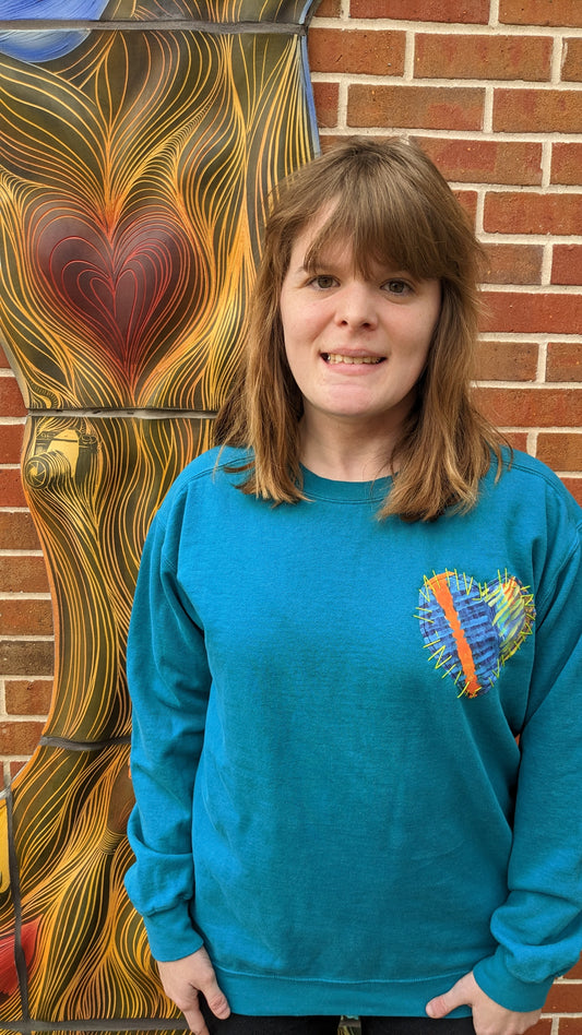 Female wearing a sweatshirt w/ Heart patch made of original artwork.