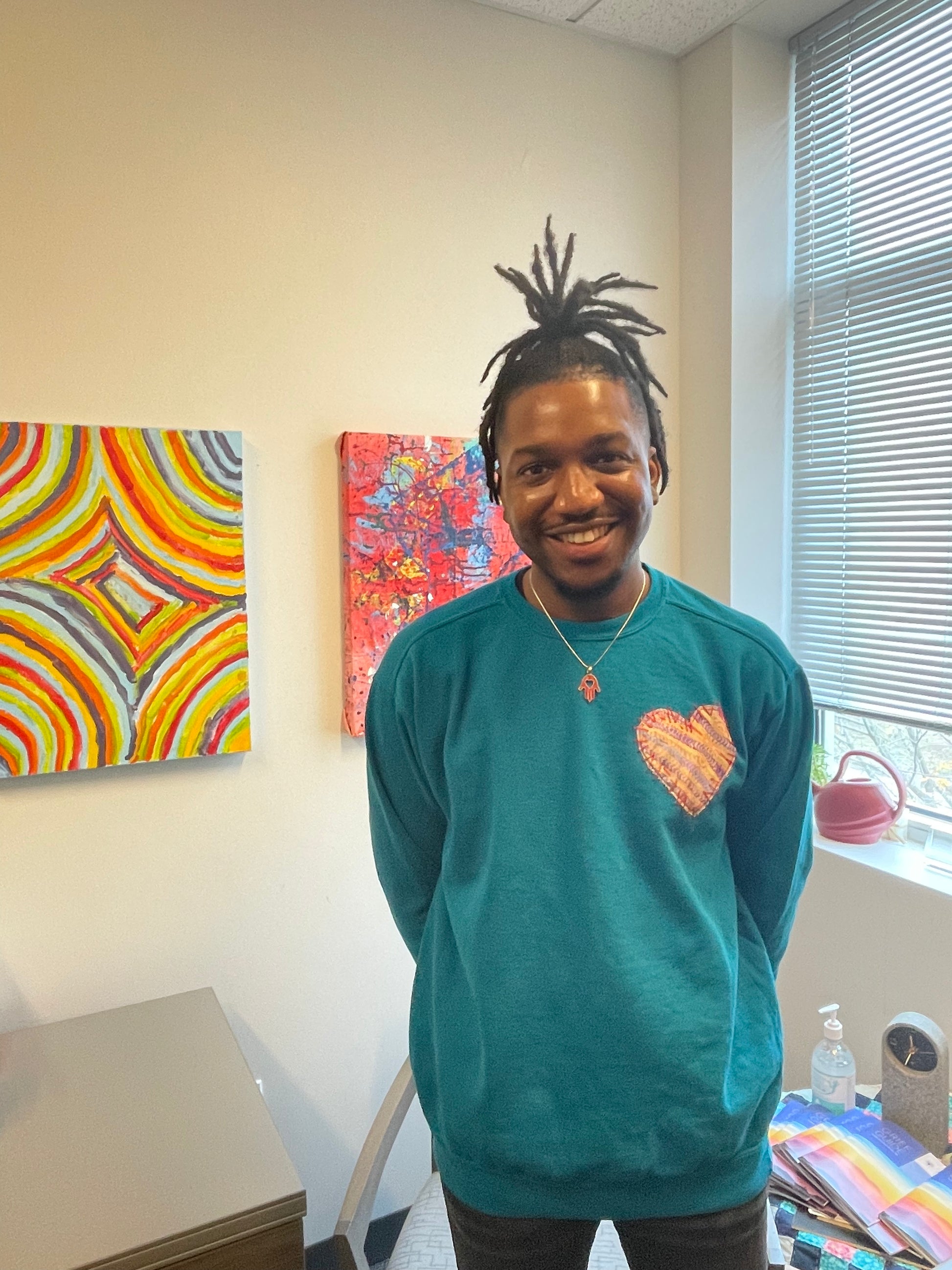 Male wearing a sweatshirt w/ Heart patch made of original artwork.