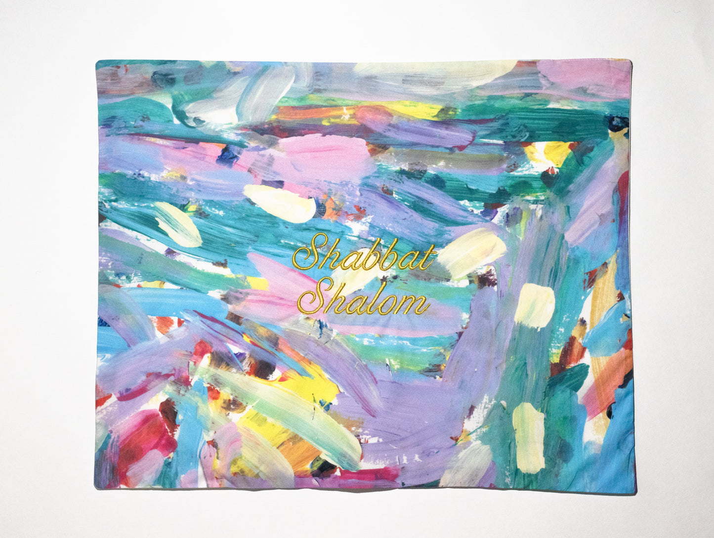 challah cover that is of an abstract pattern with pastel colors embroidered with shabbat shalom