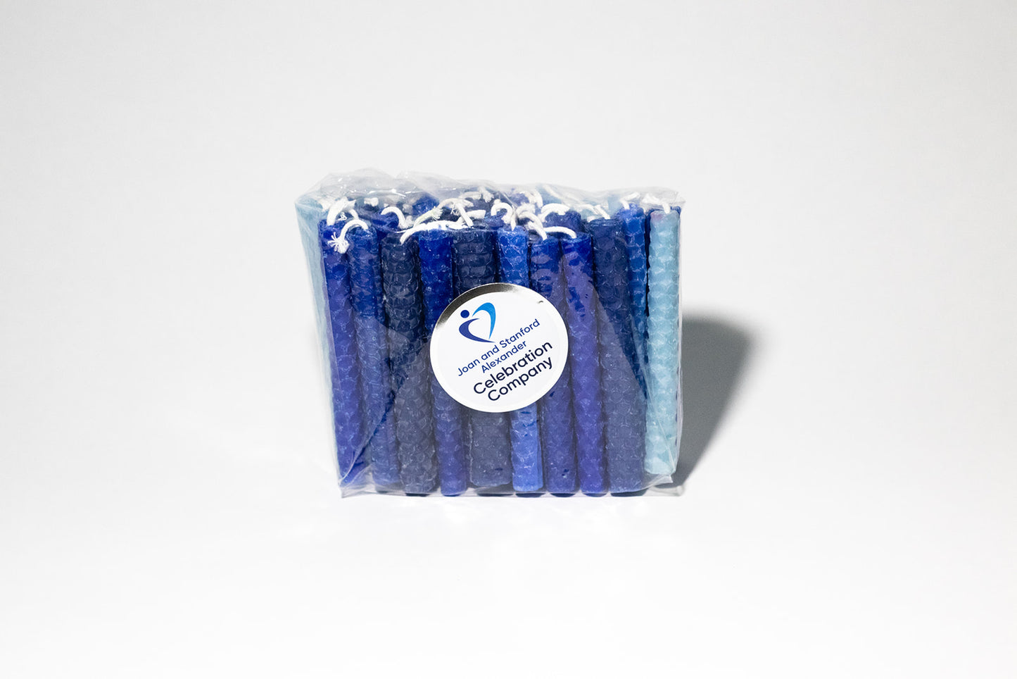 Packaged hand rolled beeswax Chanukah candles with various blue colors