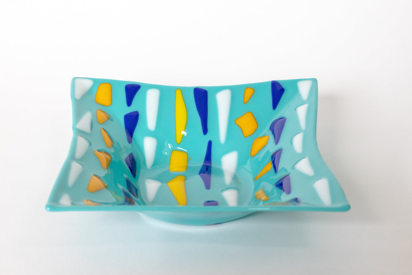 Light blue fused glass plate with white, yellow, and blue triangles pattern