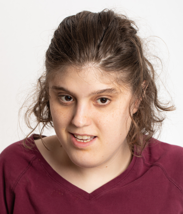 Smiling young woman wearing a garnet shirt.