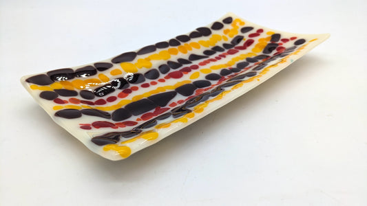 tan glass tray with rows f red, yellow and maroon