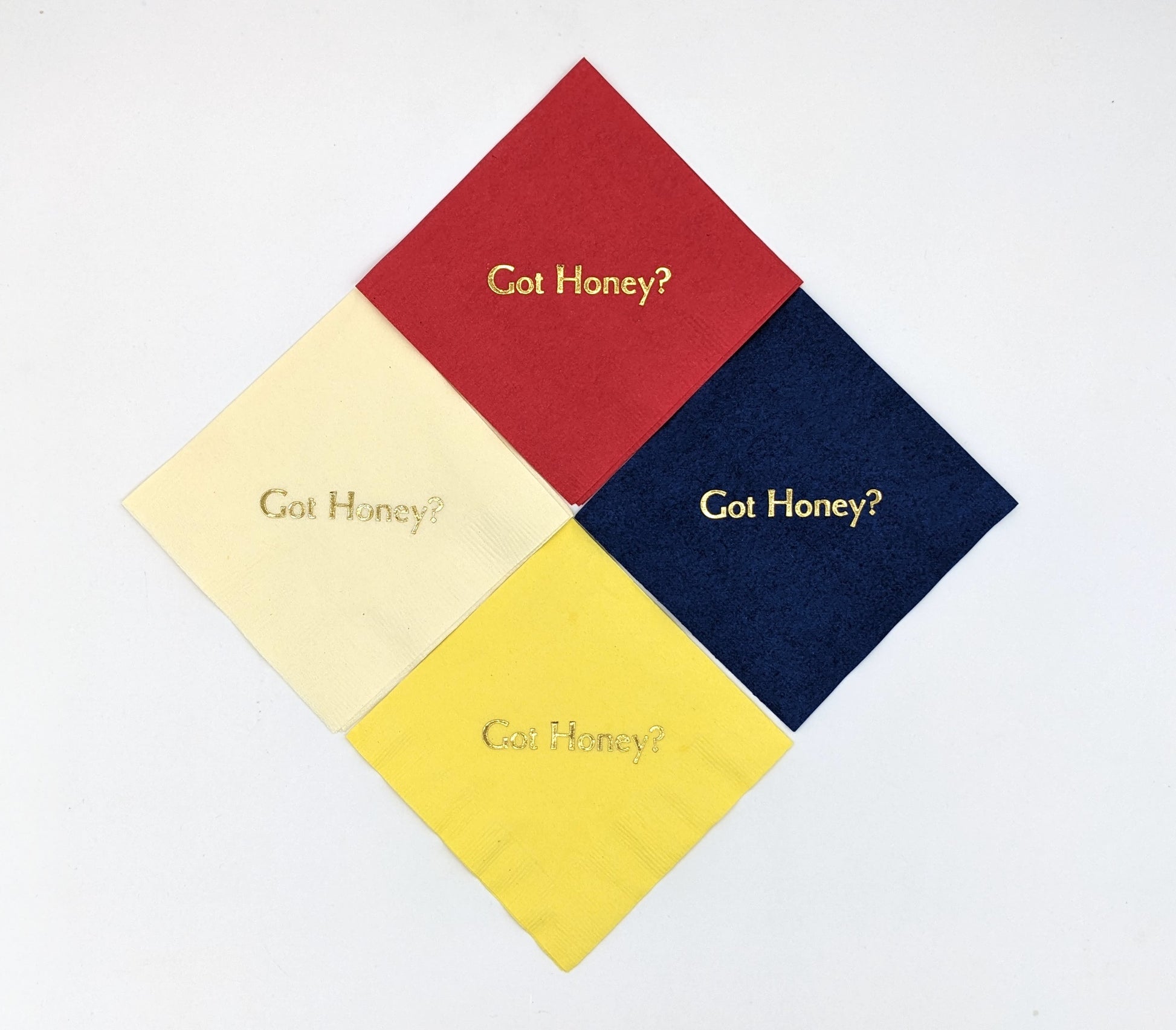 variety of napkins of cream, red, navy, yellow with the saying got honey?