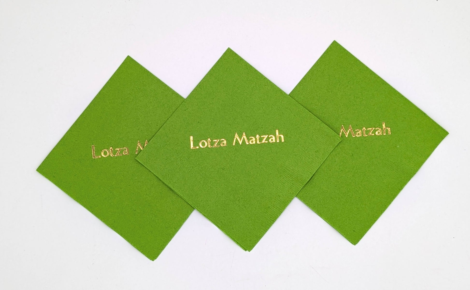 grouping of 3 lime green napkins that say lots of matzah