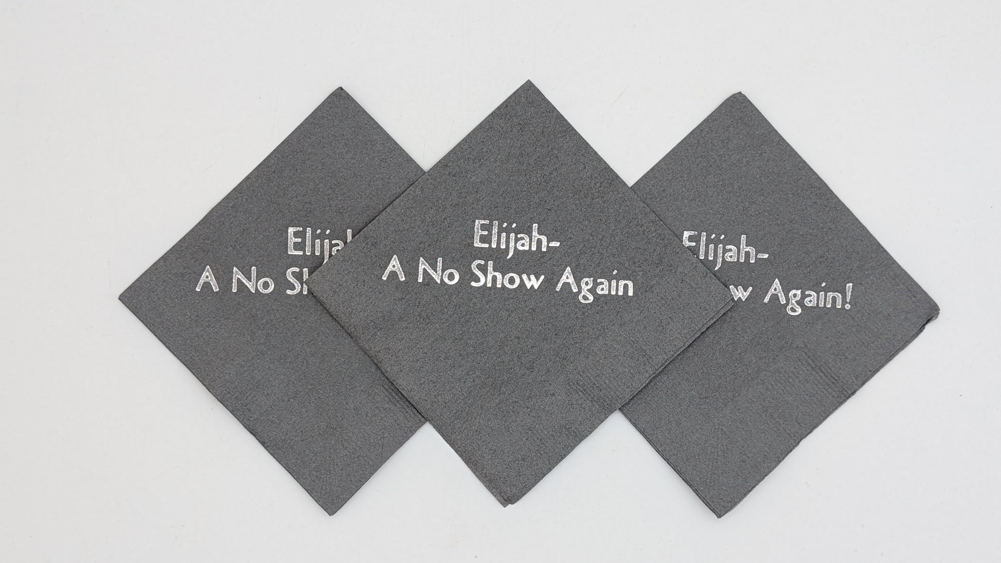 picture of 3 gray napkins with the saying Elijah a no show again