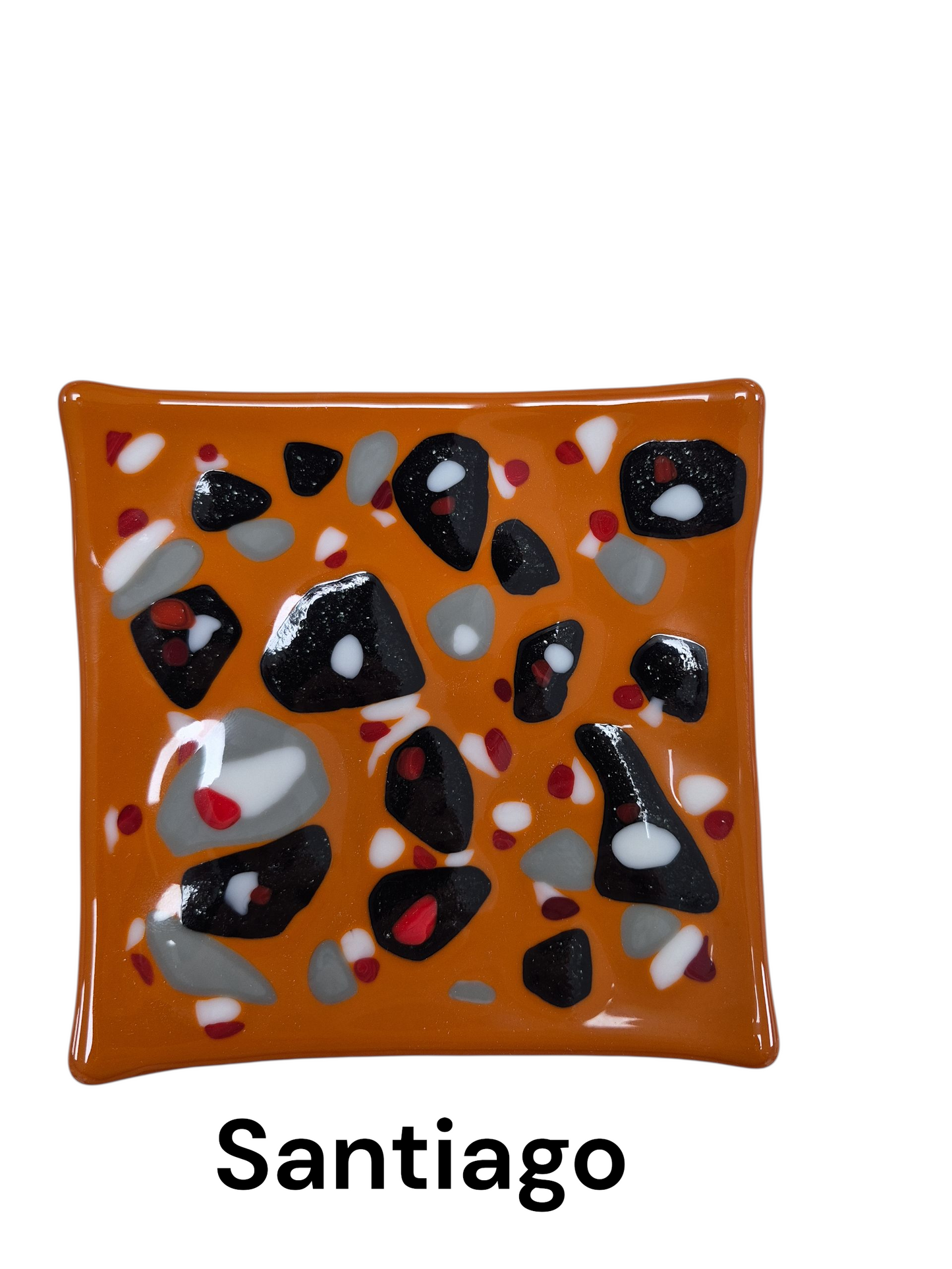 Handcrafted fused glass art tray, it features a bold, high-contrast design with an earthy orange background, punctuated by an abstract scatter of black, grey, white, and red glass accents.
Medium: Fused Glass
Size: Approximately 6" x 6"
Year: 2026