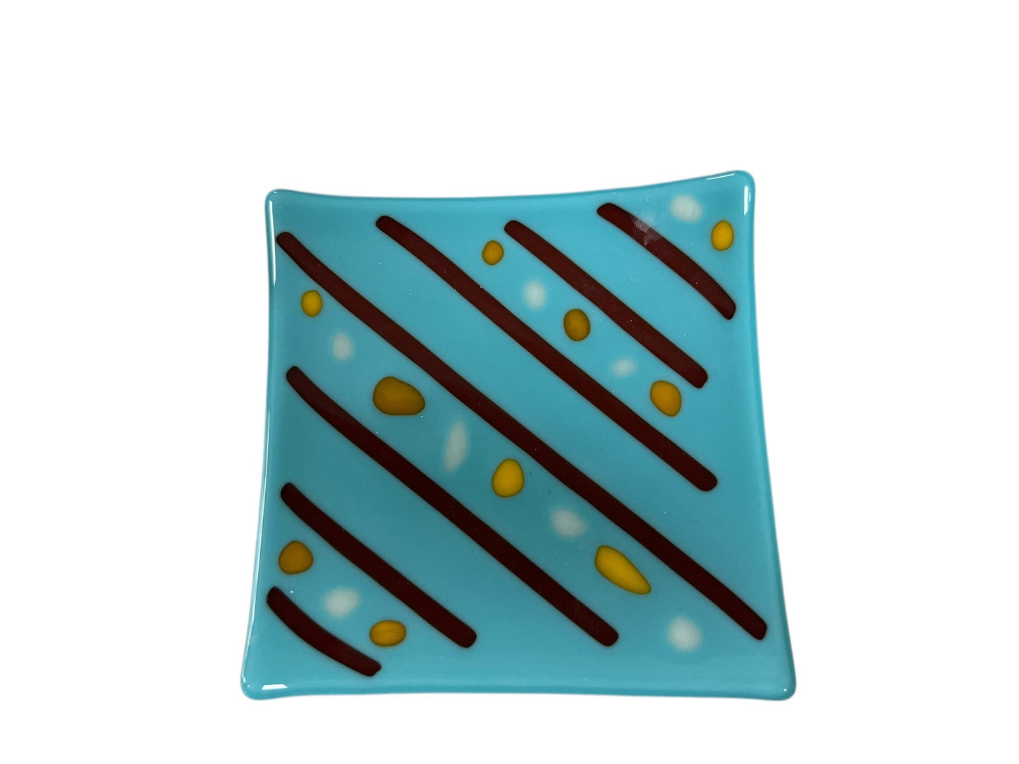 light blue glass plate with red lines diagonally and spots of yellow and white in between