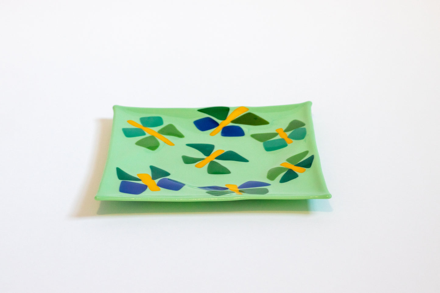 teal green glass plate with blue and green butterflies