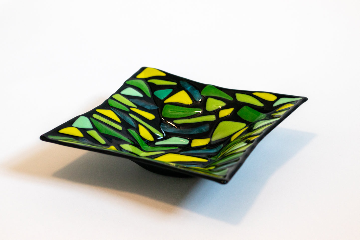 Black fused glass bowl with yellow and green designs
