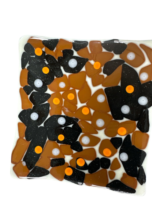 Brown glass wavy plate with Black, orange and White dots.