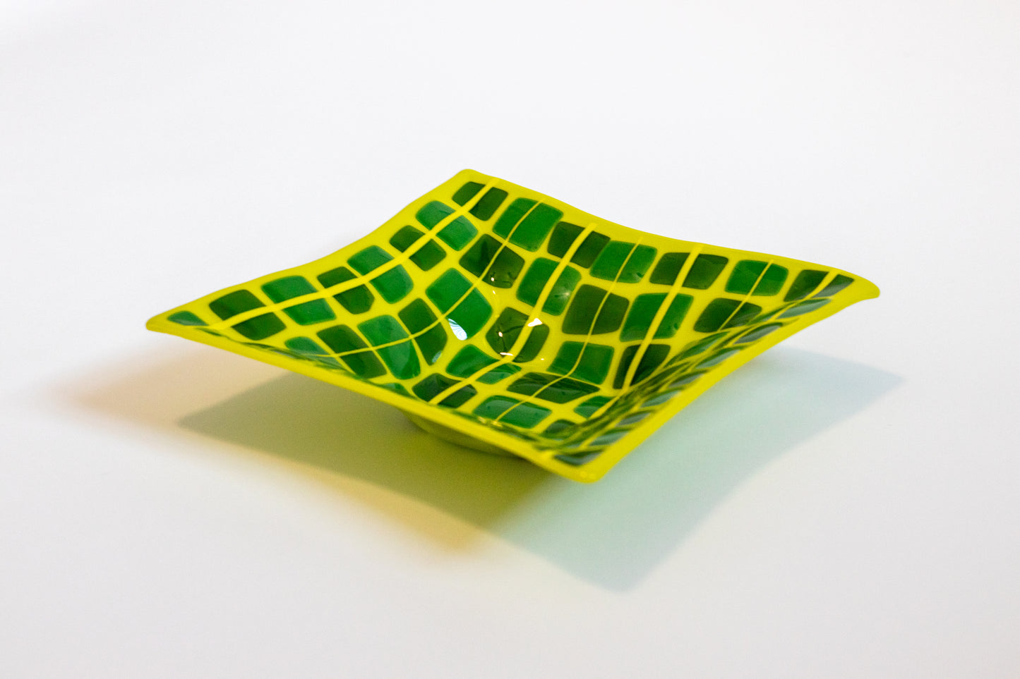 Yellow fused glass bowl dotted with green squares