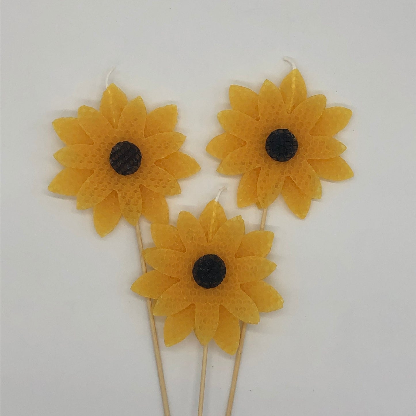 Three large yellow sunflower beeswax candles