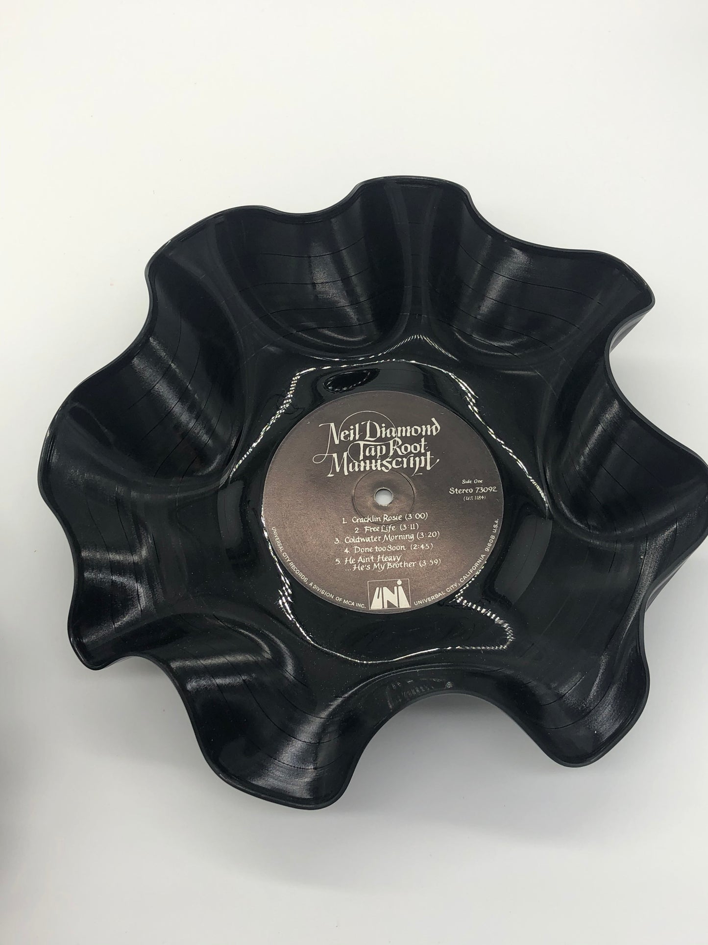 Black bowl with ruffled edges made from a melted record