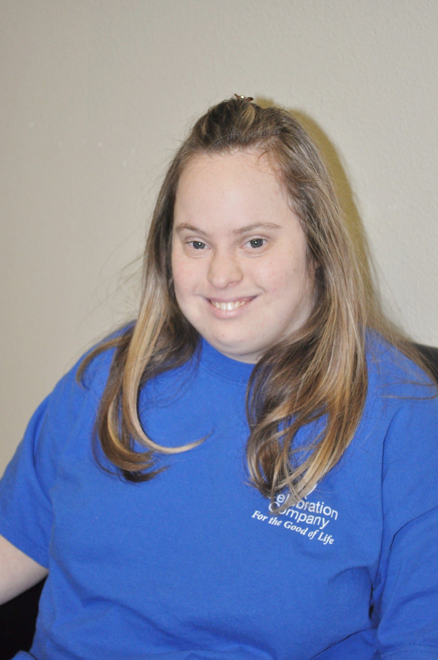 artist smiling at the camera wearing a blue shirt