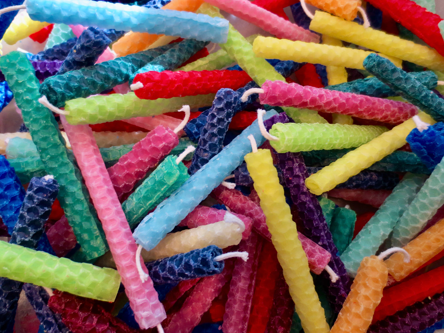 This is a photo of multicolored candles including pink, blue, purple, yellow green, orange.