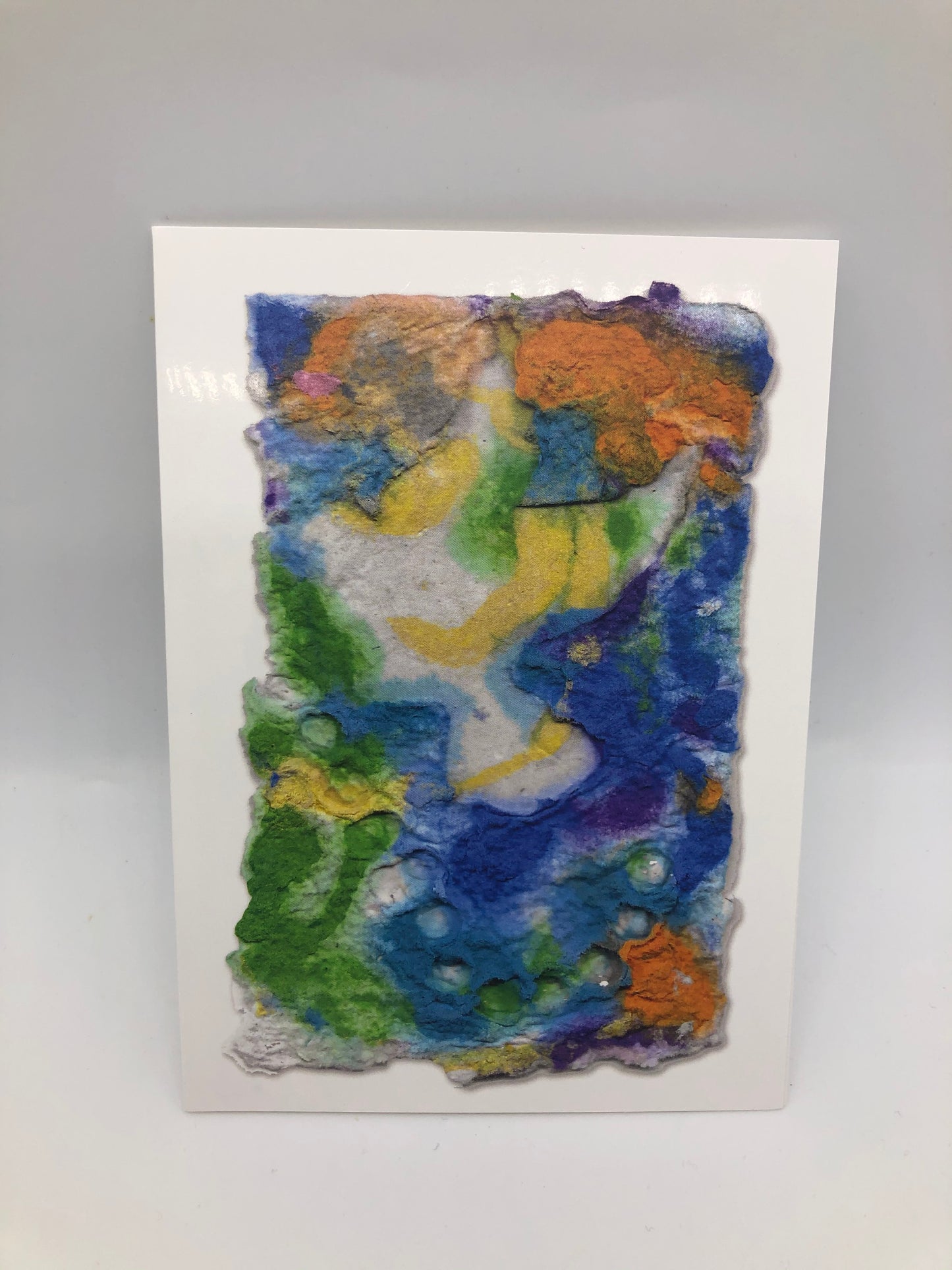 Printed photo of dove in flight made with mostly blues, greens, orange and yellow.