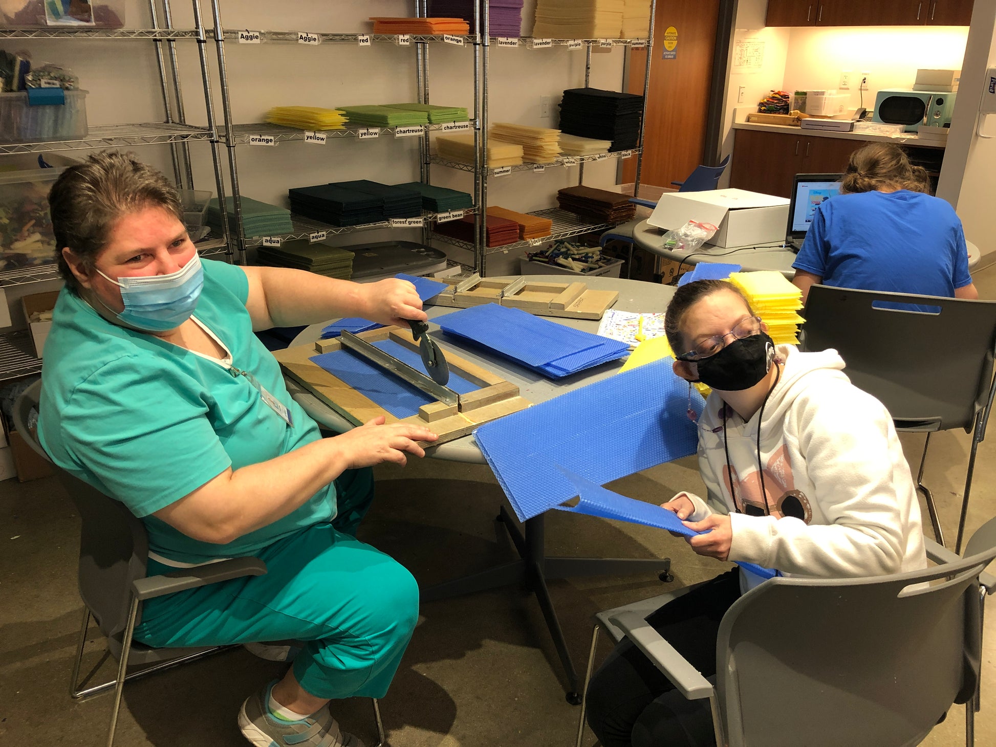 two ladies cutting blue wax