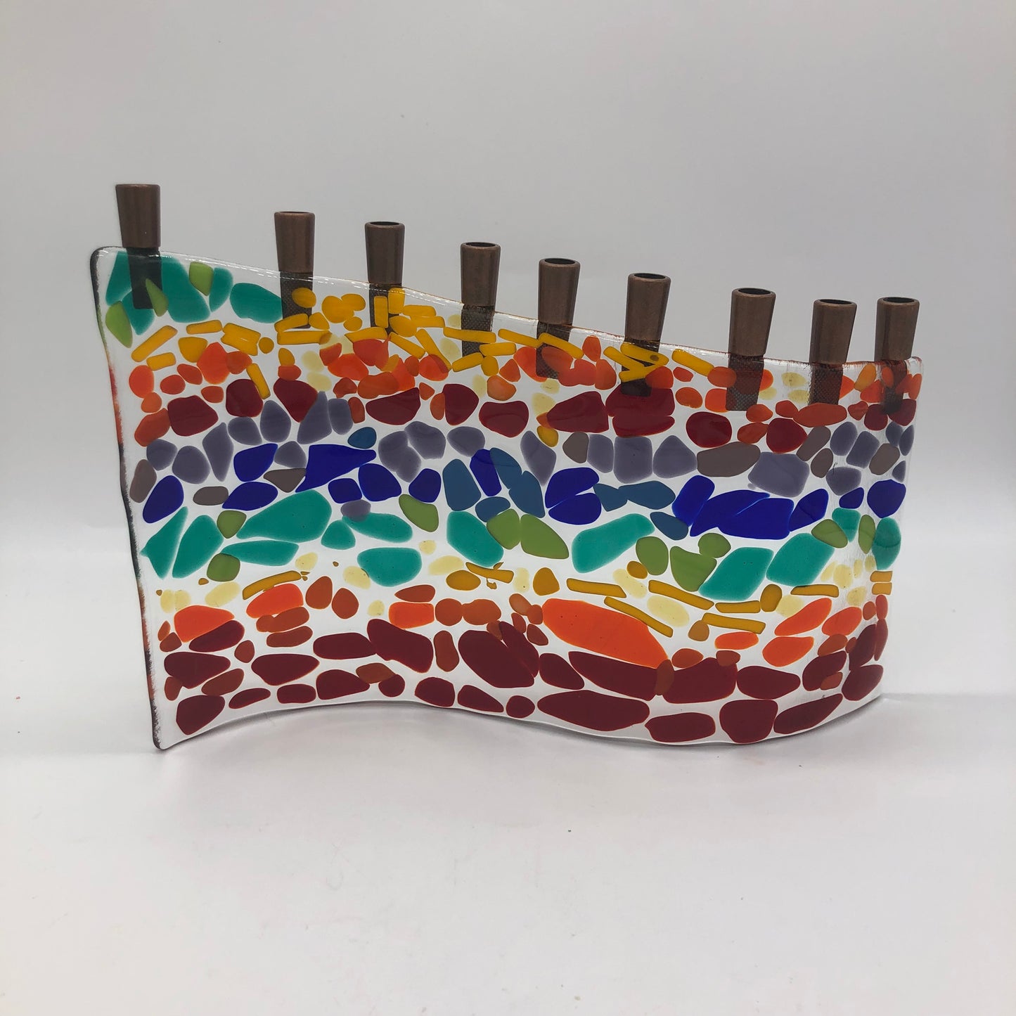 glass menorah that is a layered rows of rainbow colors