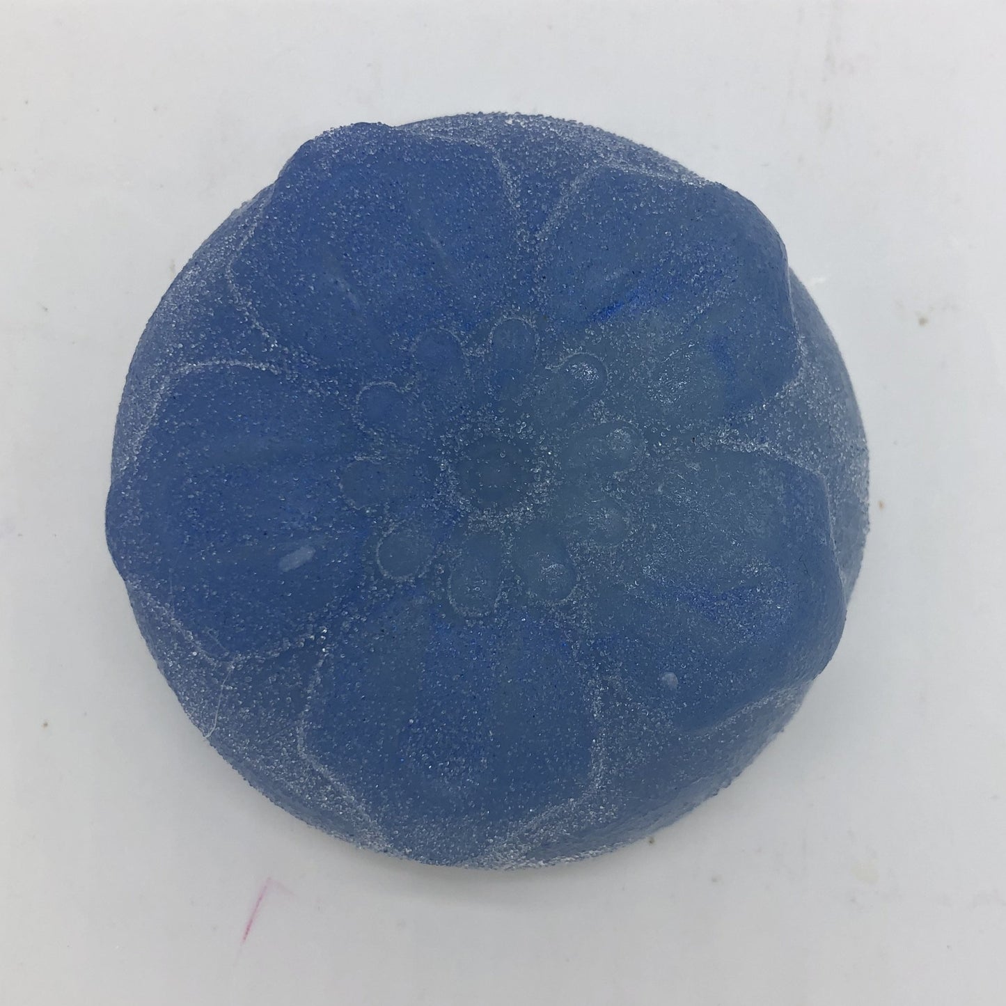 Solid blue round floral soap.