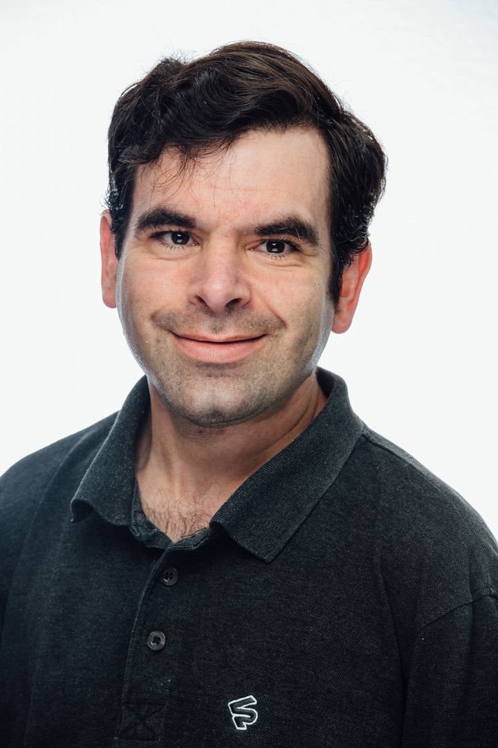 handsome young man wearing a black colored shirt and smiling at the camera