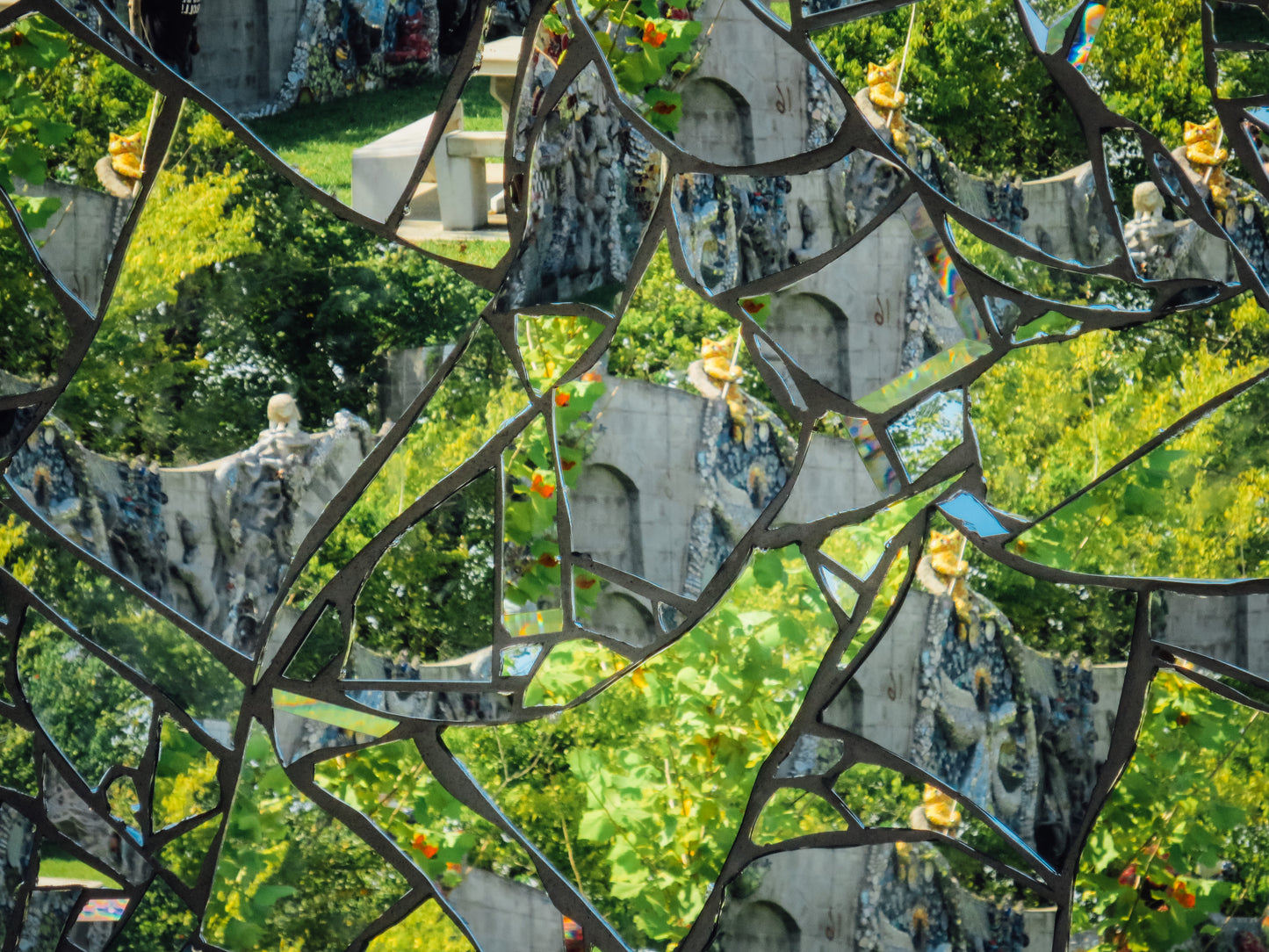 Photograph of broken mirrors reflecting leaves