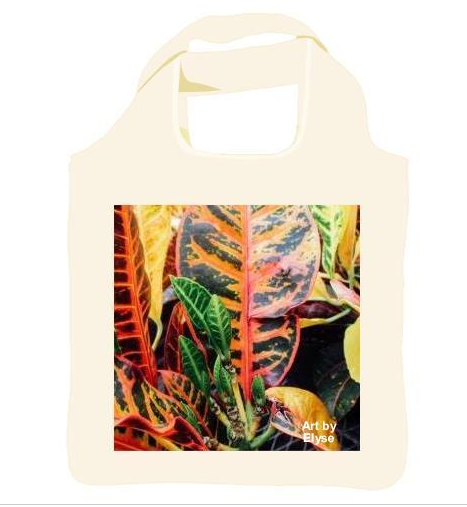 Reusable shopping tote with an image of a Photograph of a close up of green leaves sprouting in the center of the plant, surrounded by larger leaves with red veins