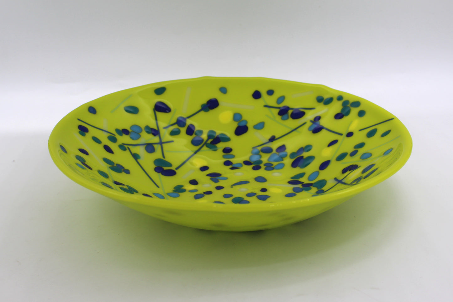 green bowl with blues speckled around with a few lines
