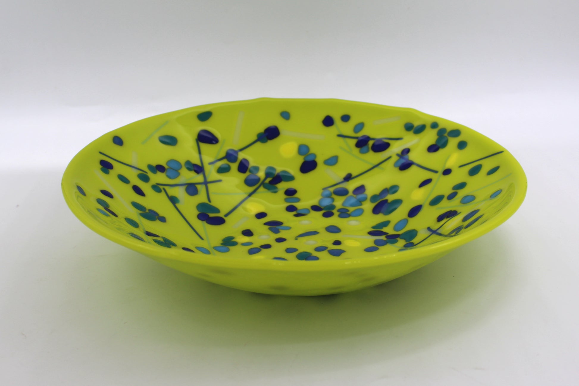 green bowl with blues speckled around with a few lines