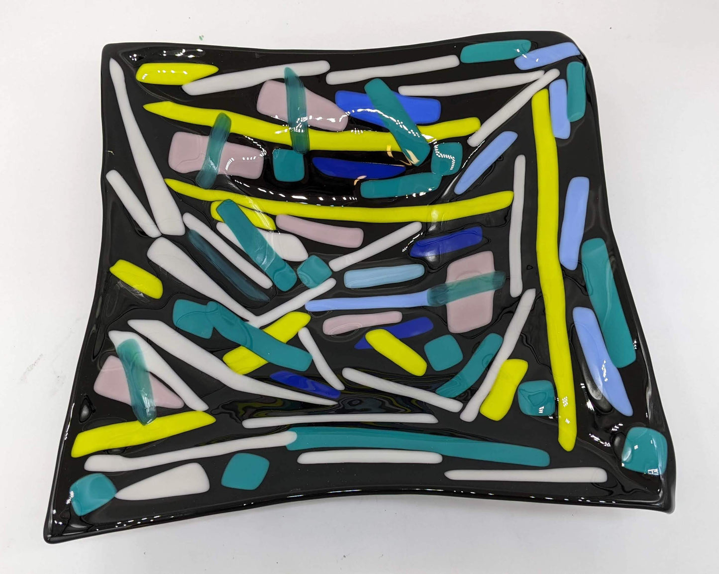 black glass square bowl with lines of greens, white, and blues overlapped