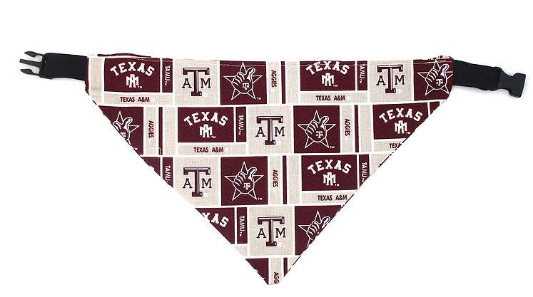Photo of triangular dog bandana with black plastic closure.  Background of fabric is light gray with several maroon boxes with the A&M logo, the Gig Em graphic, Aggies and TEXAS in maroon.