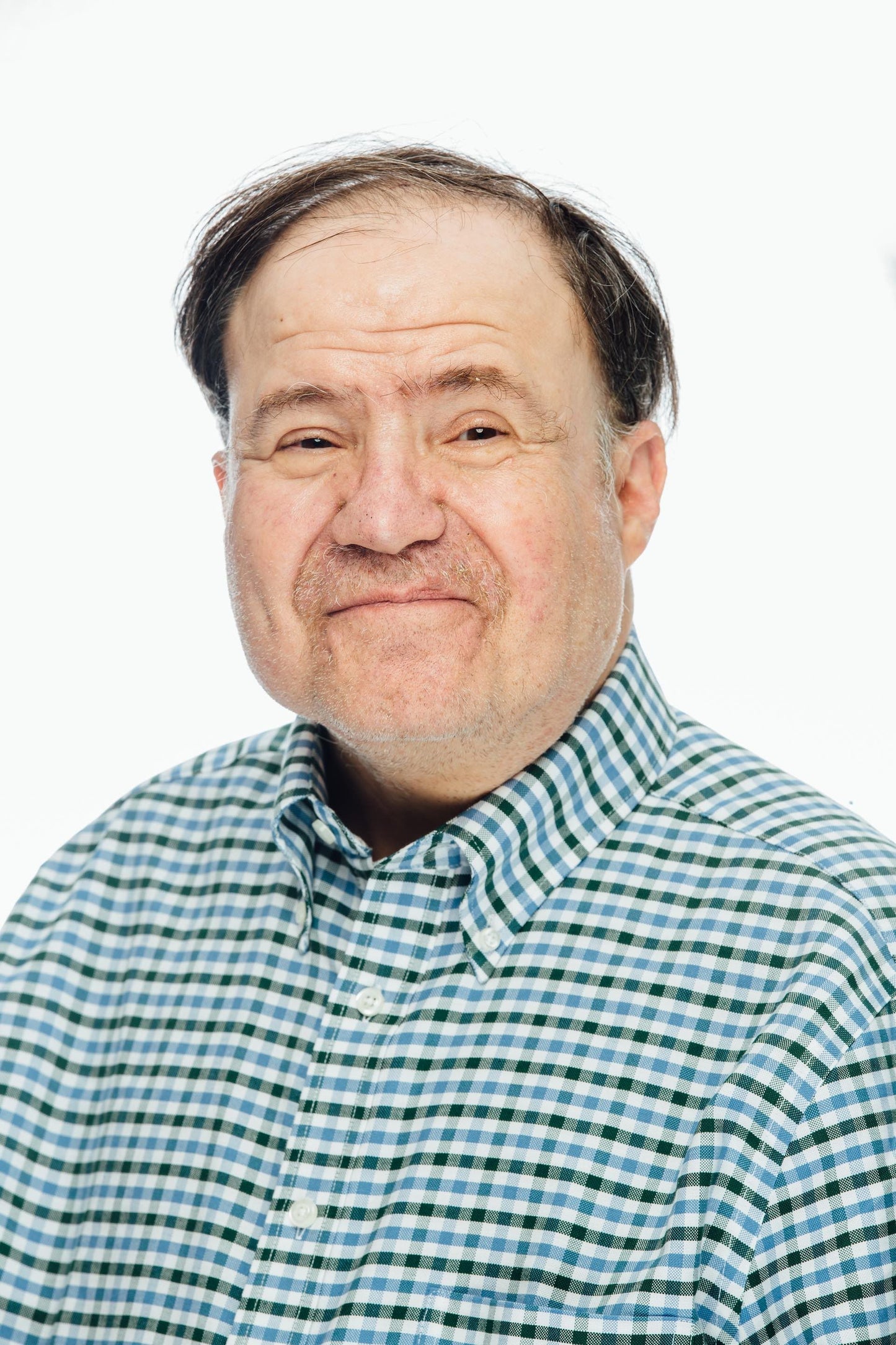 man, slightly balding, smiling, wearing a blue and black checkered button down shirt