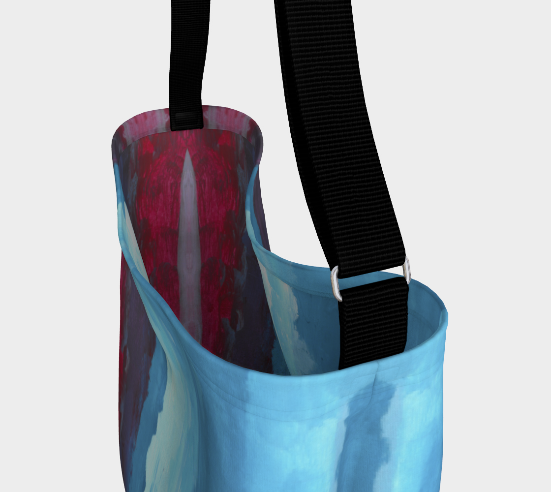 Close up photo of Crossbody bag showing black strap with red, light blue and dark blue gradient design
