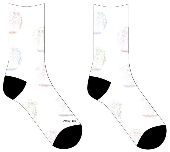 White socks with circles of tinted color of Graphite drawing of a person with a hat and coat standing. The facial features are drawn darker and finer than the shaded outlines. There are faint buttons drawn going down the torso of the person