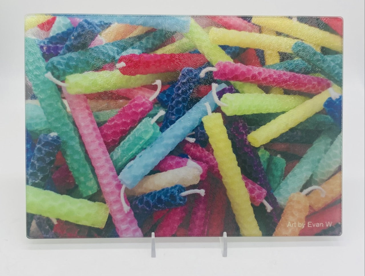 This is a cutting board with a photo of multicolored candles including pink, blue, purple, yellow green, orange.