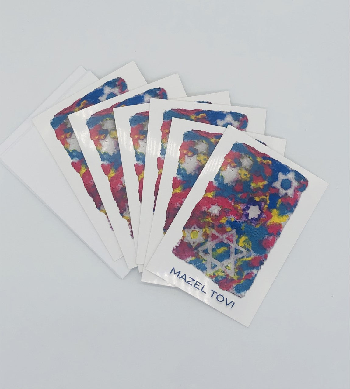 Pack of Graphic greeting cards with blue, red and yellow Jewish stars with Mazel Tov at the bottom