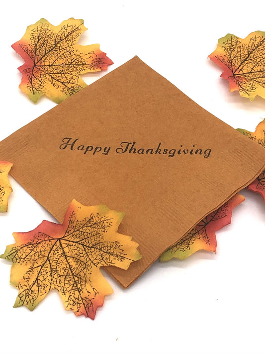 Light brown cocktail napkins with dark brown Happy Thanksgiving slogan