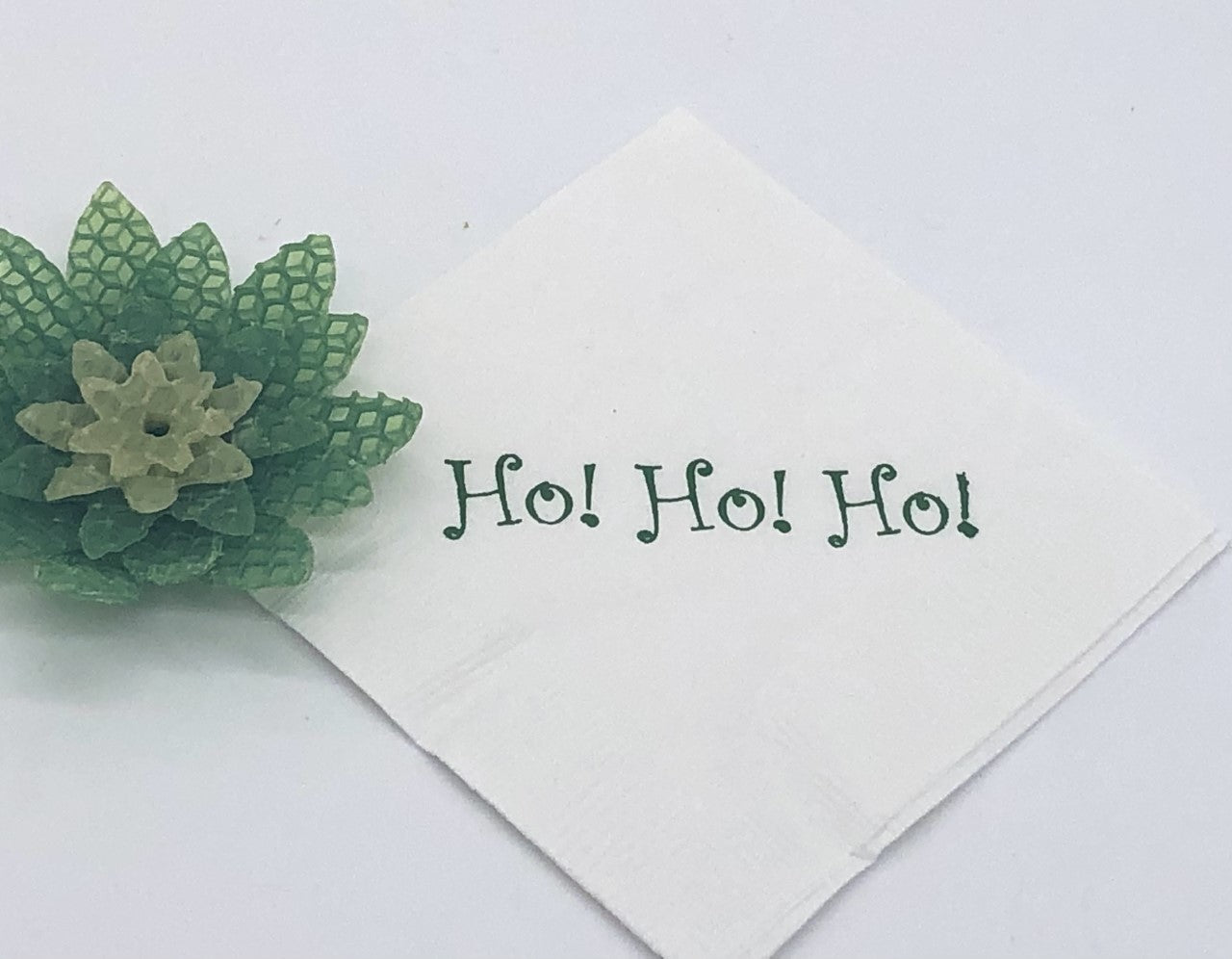 White cocktail napkin with green Ho! Ho! Ho! slogan