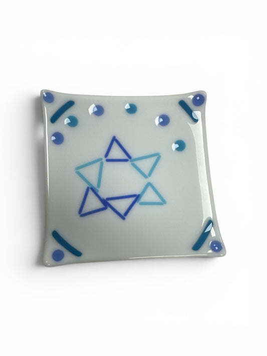 This is a square, white fused-glass decorative dish featuring a central Star of David design made from alternating shades of blue triangles, accented by matching blue dots and corner lines.