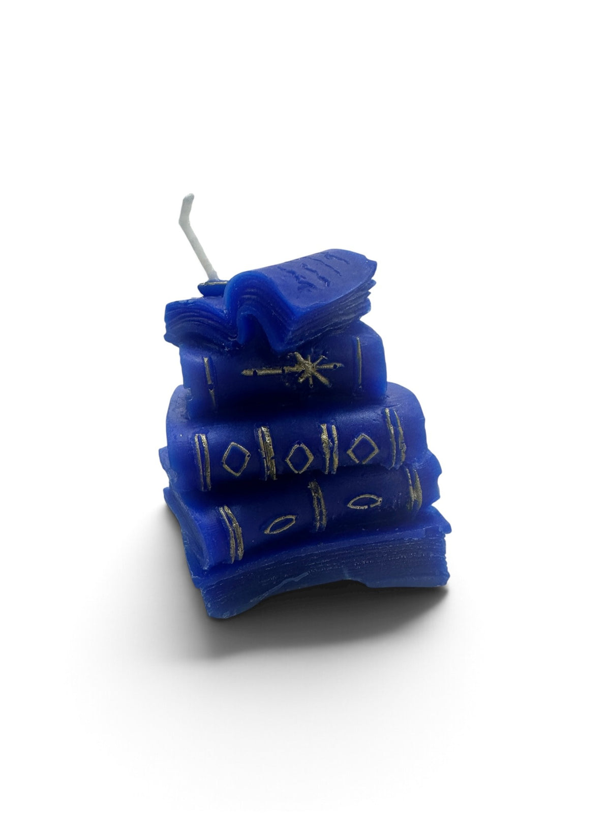 A miniature stack of blue book candles with gold-detailed spines topped with an open book wick.