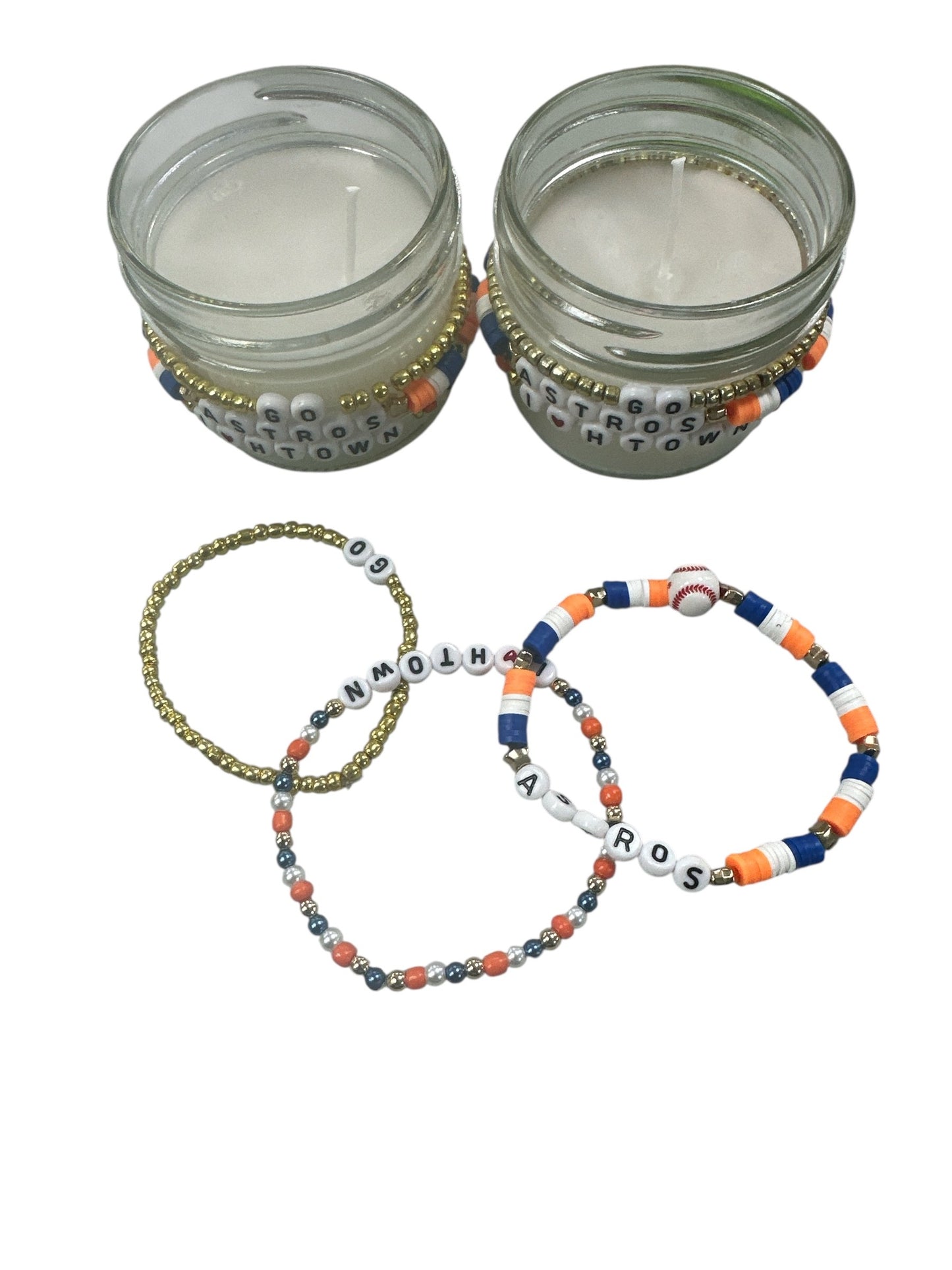 White candle with a astros bracelet attached around.