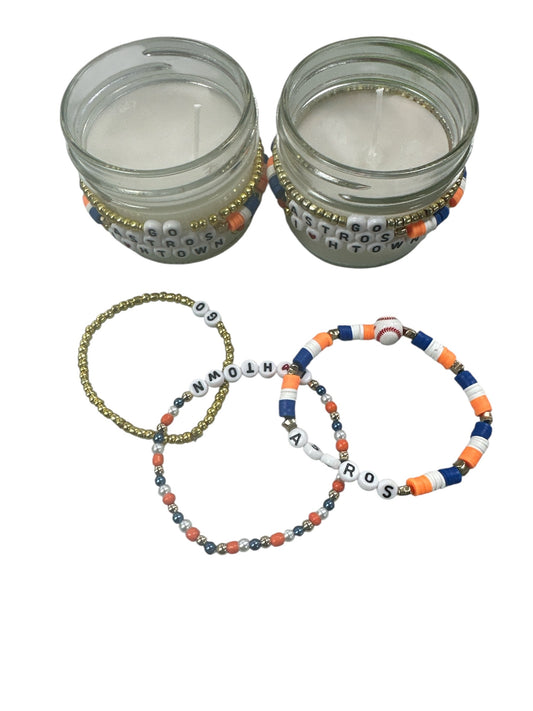White candle with a astros bracelet attached around.