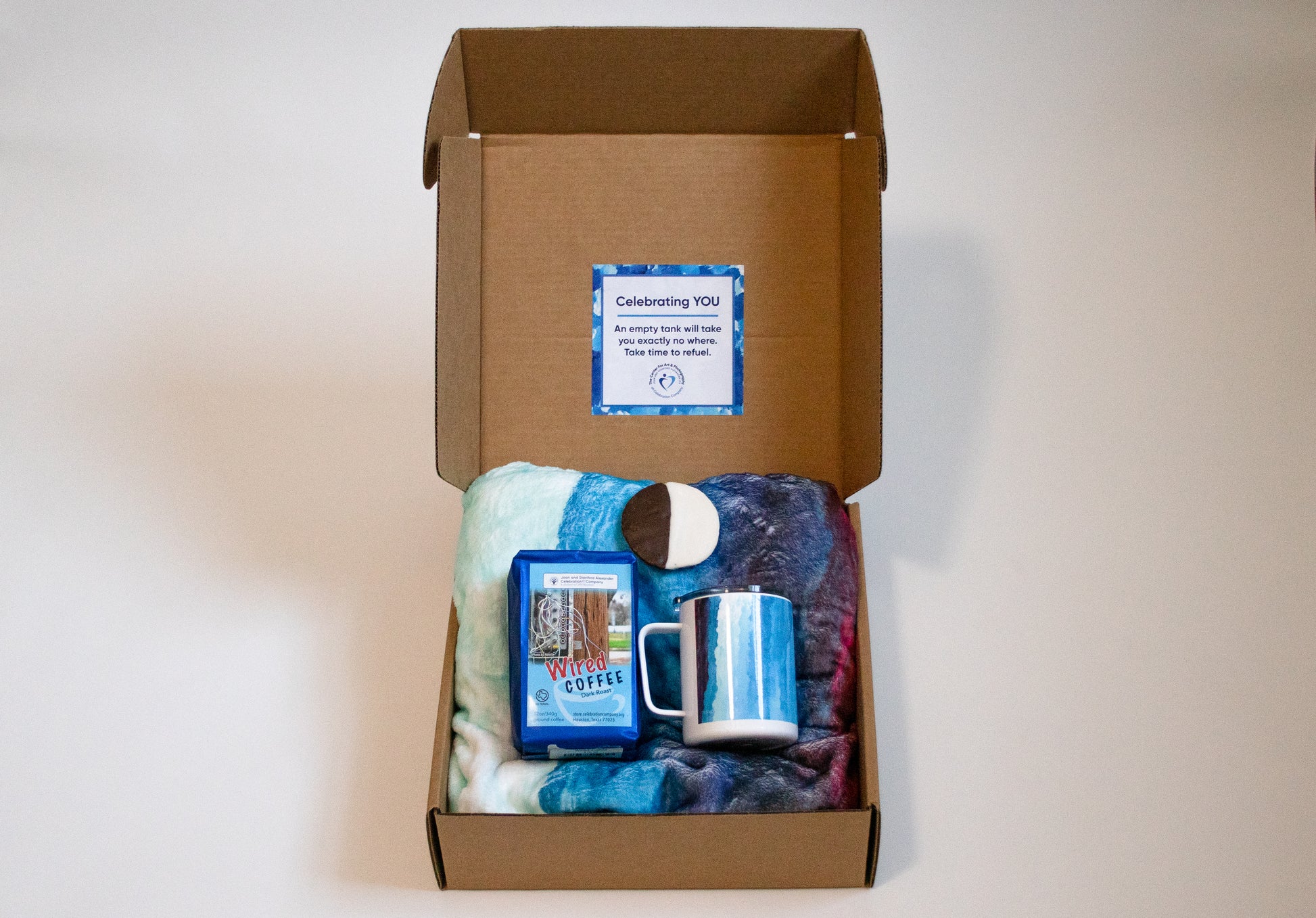 box with blanket mug, cookie and coffee