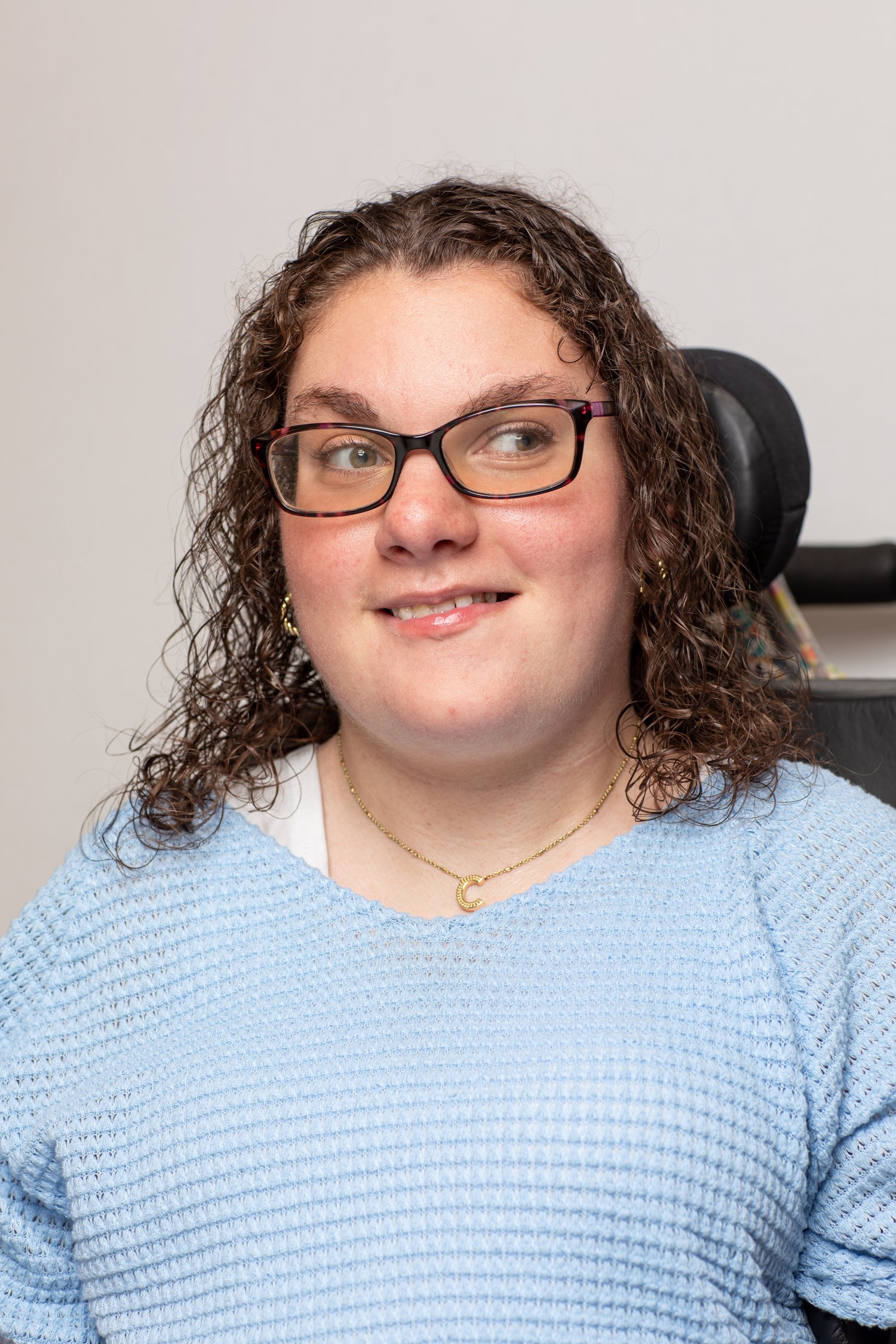 picture of young woman with curly hair wearing a blue shirt