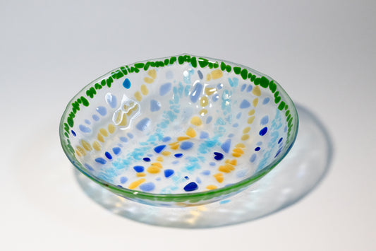 clear glass bowl with stripes of yellow and blue alternating with a border of green