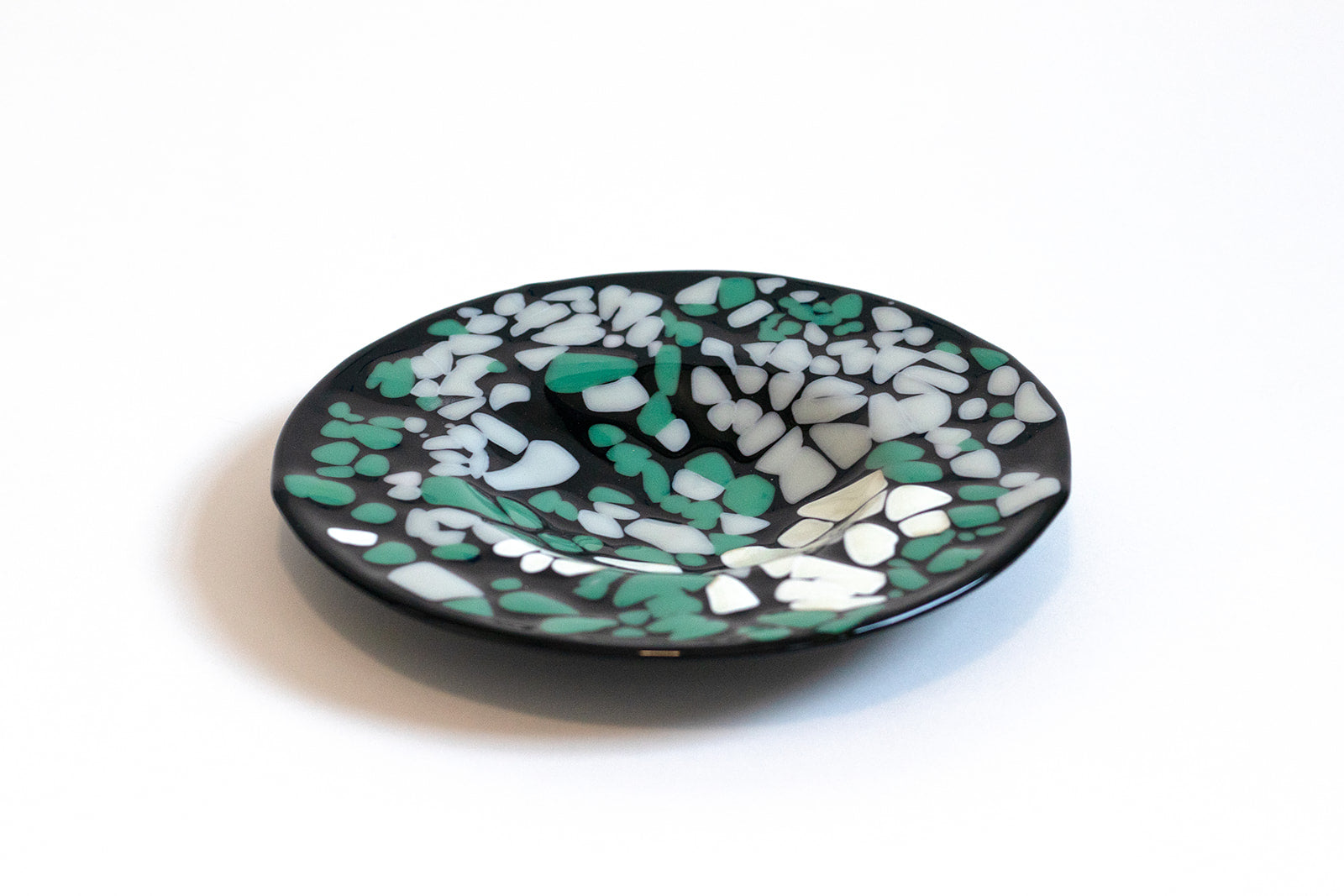 black circular bowl with dots of gray and teal