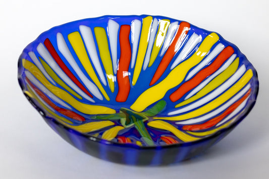 blue bowl with lines of yellow, white, and orange radiating in the center