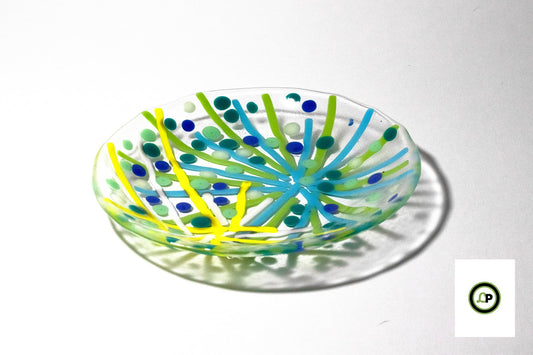 glass plate with star bursts made of yellow and green lines surrounded by dots