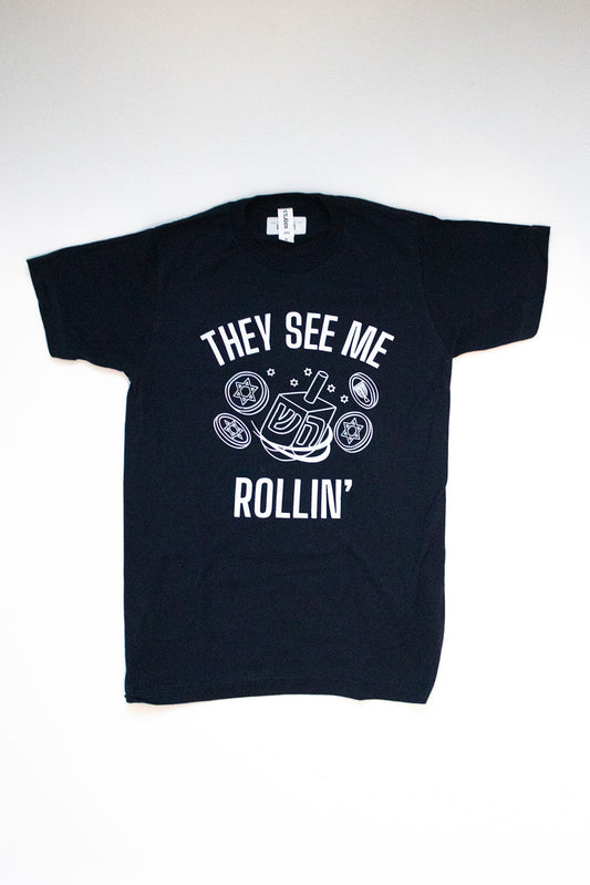 black shirt that says they see me rolling